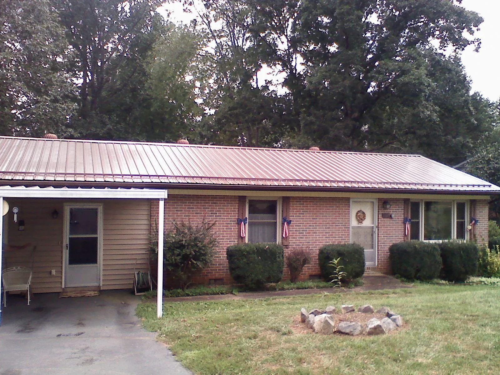 Bronze metal roof and carport on a brick ranch home — Roof Repair work by our crew in Blencoe